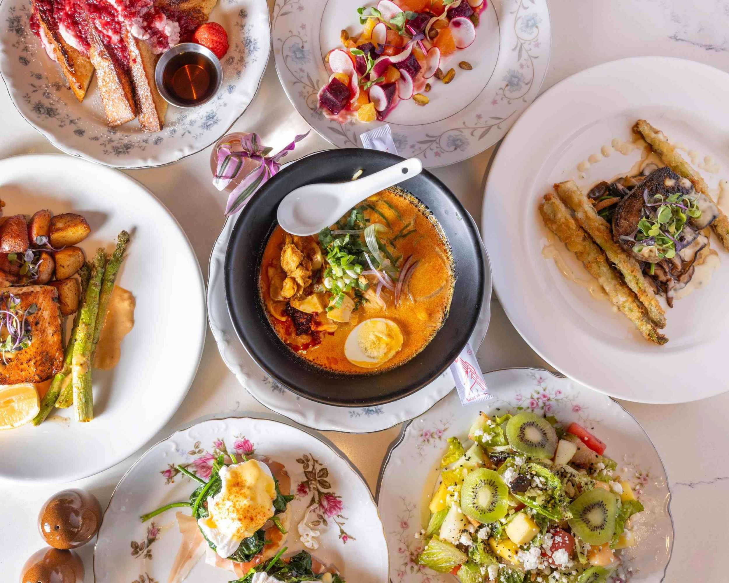 Variety of plated dishes including soup, salad, and desserts on a table.