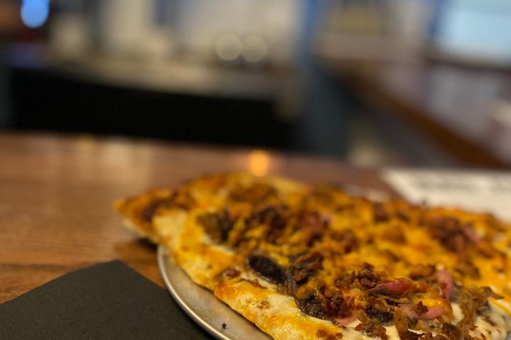 a slice of pizza sitting on top of a wooden table
