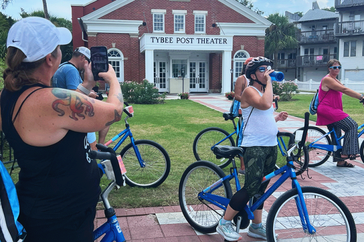 a group of people standing next to a bicycle
