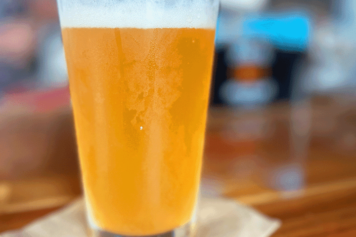 a close up of a glass of beer on a table