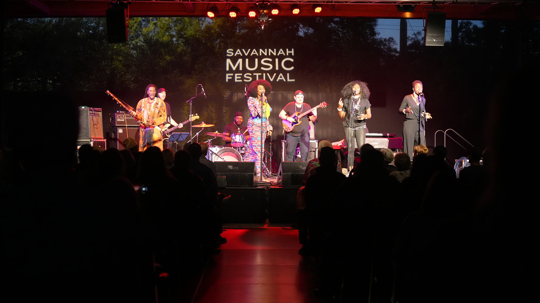 Band performing on stage at Savannah Music Festival with audience in foreground.
