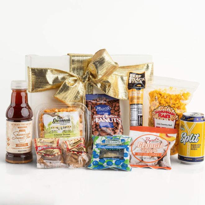 Gift box with snacks, drink, golden bow on white background.