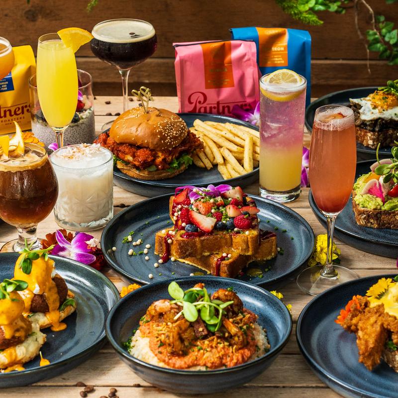 An array of diverse foods and colorful drinks on a wooden table.