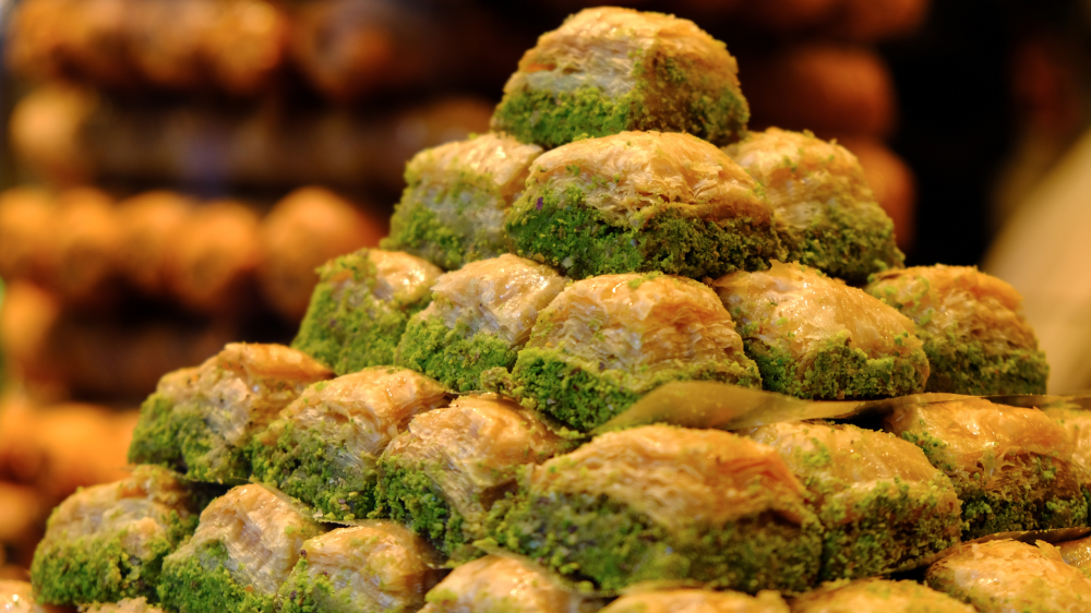 Pyramid of baklava pieces garnished with green pistachio.